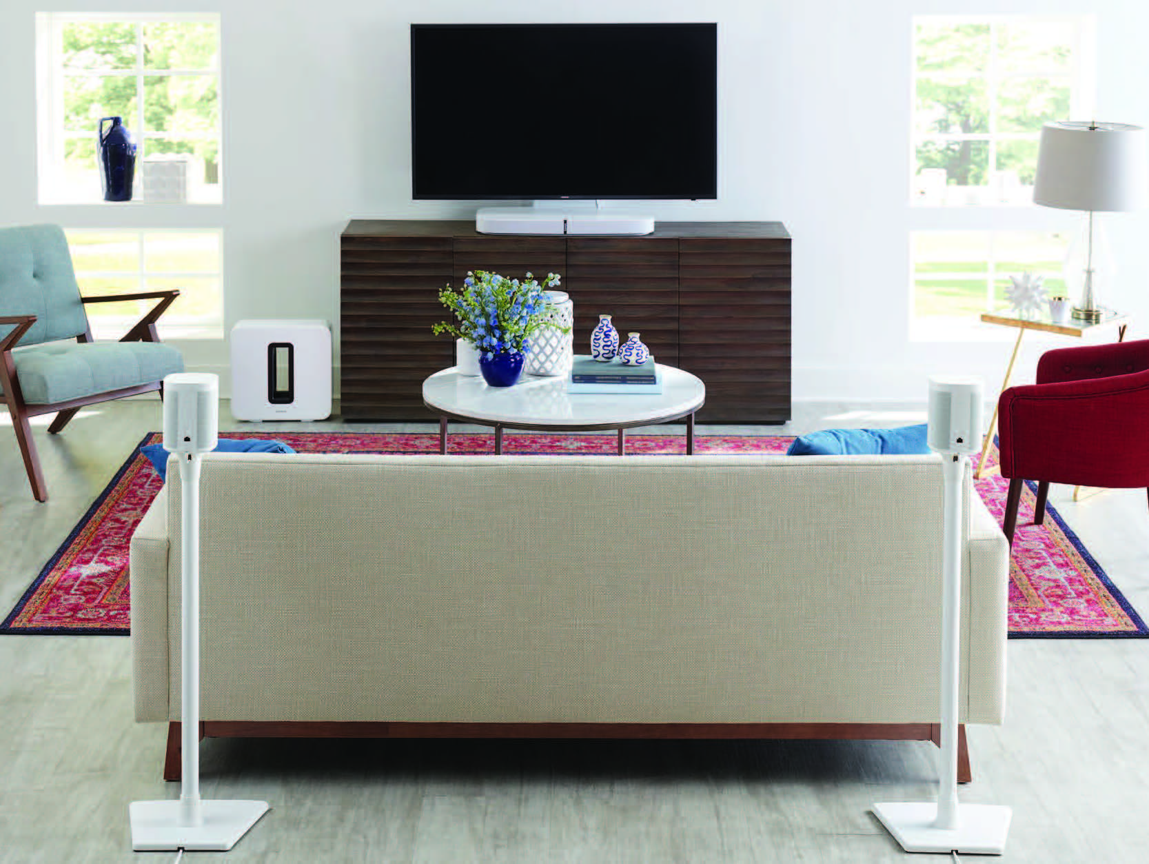 A lifestyle image of wireless speaker mounts, stands, and bases designed for Sonos® Home Sound System displayed in a living room